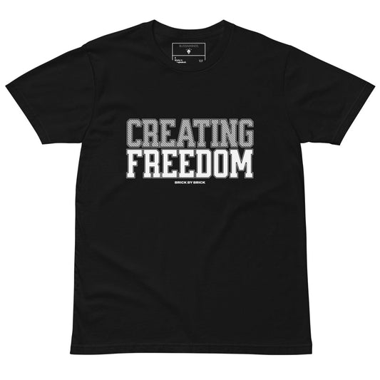 Black tee with bold gray and white text “Creating Freedom” and small “Brick by Brick” centered below.