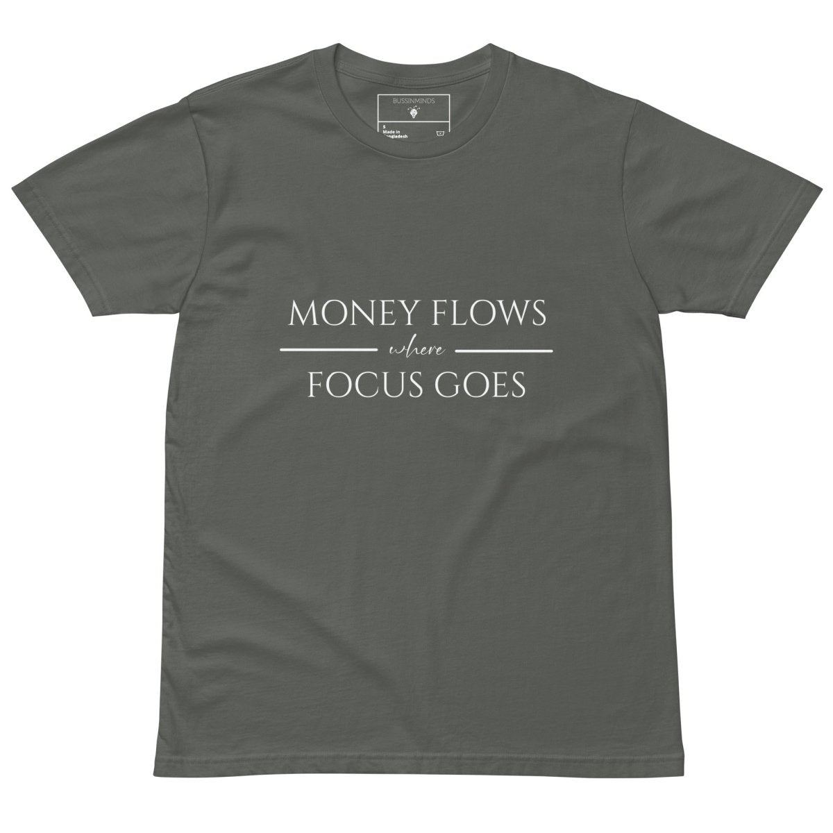 Green tee with white text “Money Flows Where Focus Goes” in elegant serif font, with horizontal lines next to “where"