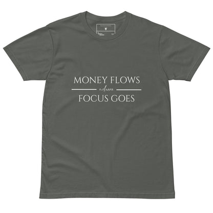 Green tee with white text “Money Flows Where Focus Goes” in elegant serif font, with horizontal lines next to “where"