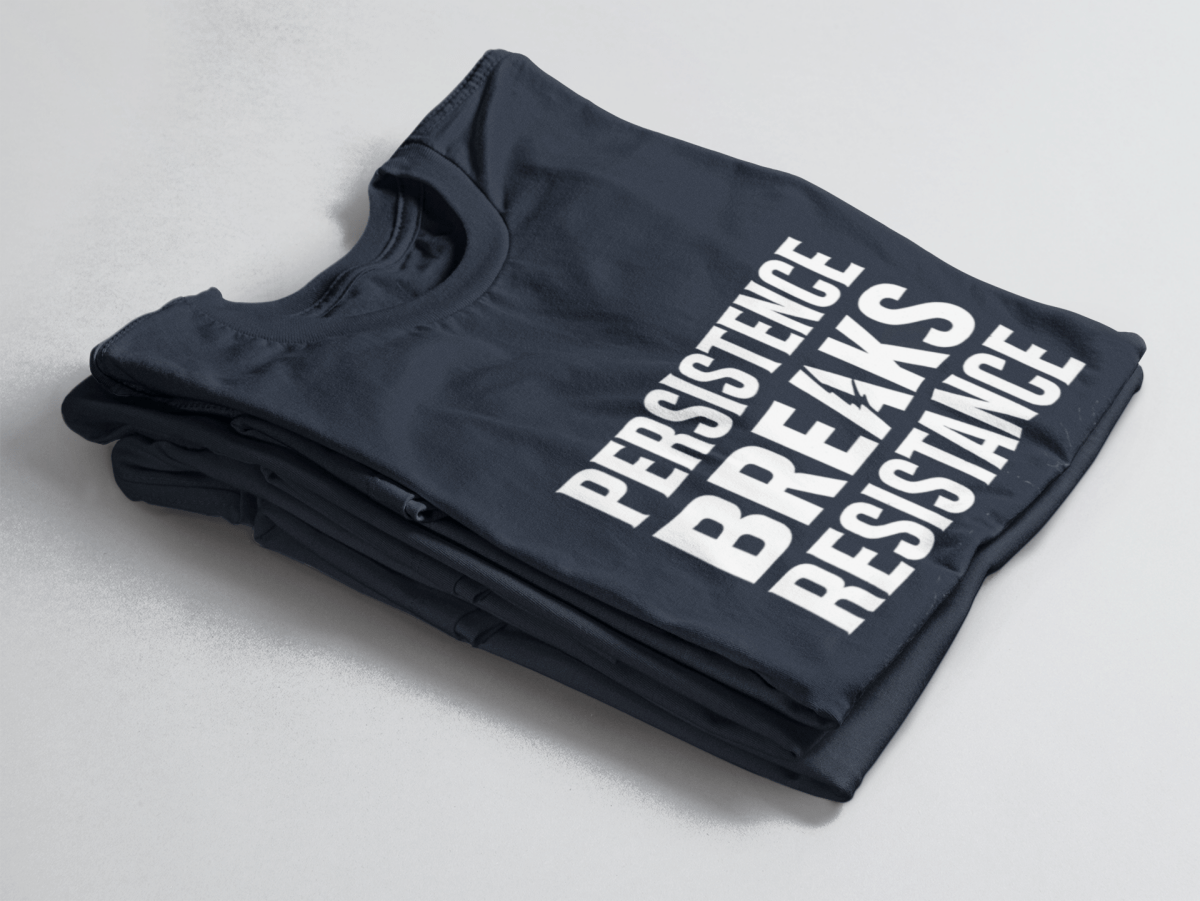 Navy folded t-shirt with bold white text “Persistence Breaks Resistance” and a lightning bolt in the letter “A” of BREAKS.