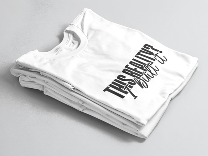 White folded tee with bold outlined text “This Reality?” above cursive “I built it” in white script.