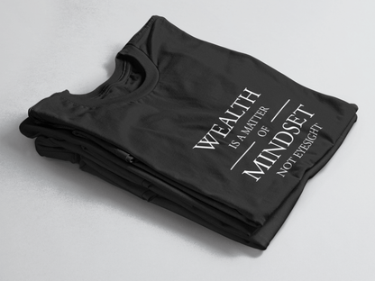 Black folded tee with white text “Wealth is a Matter of Mindset, Not Eyesight” in elegant serif font with horizontal lines.