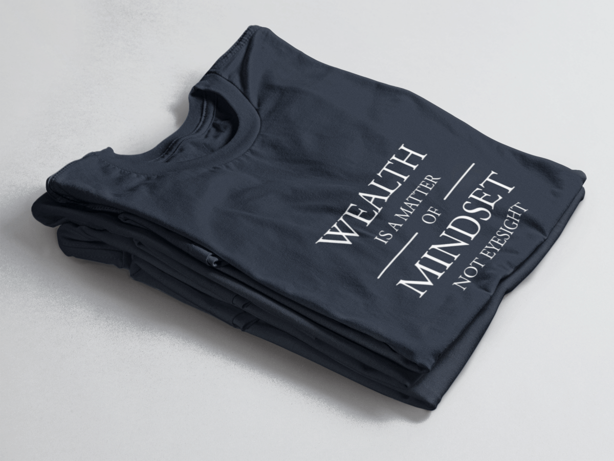 Navy folded tee with white text “Wealth is a Matter of Mindset, Not Eyesight” in elegant serif font with horizontal lines.