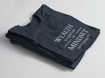 Navy folded tee with white text “Wealth is a Matter of Mindset, Not Eyesight” in elegant serif font with horizontal lines.